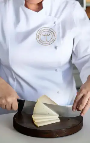 SEO Agency Project for La Dehesa Woman cutting La Dehesa cheese in an image of her website positioned by our SEO Agency.